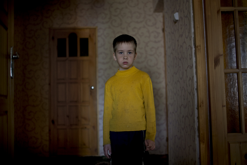 Dima Dmitry, 8, a fourth generation Russian German, stands for a portrait at home in Korotkeros, Russia. 