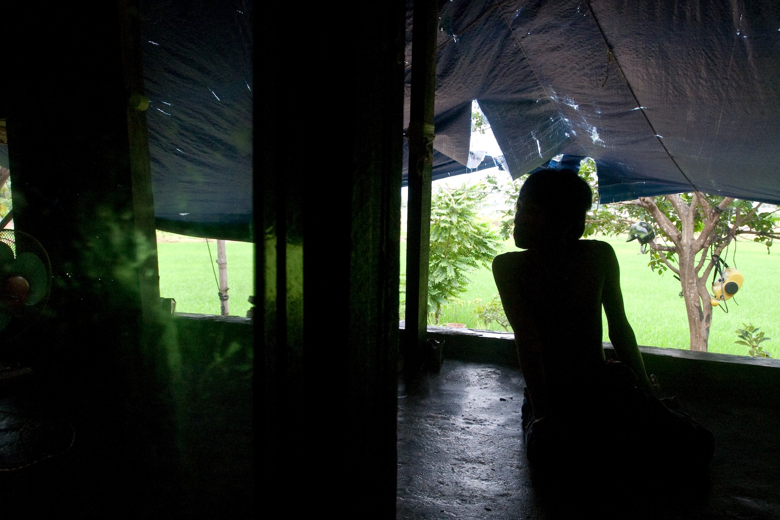 Le Sinh, 14, Agent Orange victim, looking out from the lanai at home in the Benh Vien district, Da Nang Vietnam.
