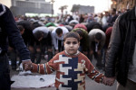 A young Egyptian protester takes part in securing  prayers at Tahrir Square in Cairo.Tuesday, February 8, 2011