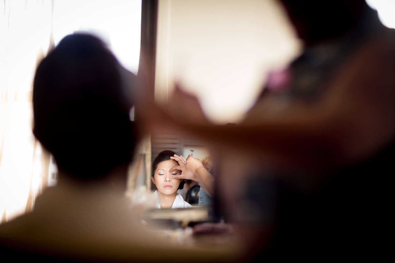 The bride has her makeup applied at the Washington Athletic Club (WAC) prior to the start of her wedding at the Seattle Aquarium. (Wedding Photography by Scott Eklund/Red Box Pictures)