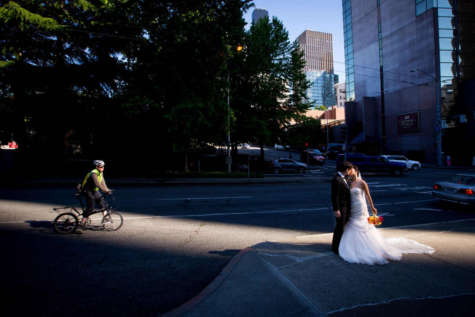 The bride and groom share a kiss in downtown Seattle prior to the start of their wedding at the Seattle Aquarium. (Wedding Photography by Scott Eklund - Red Box Pictures)