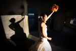 The bride raises her bouquet as she celebrates her wedding at the Seattle Aquarium. (Wedding Photography by Scott Eklund - Red Box Picures)