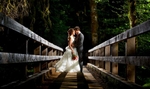 The bride and groom kiss on a bridge during their Lake Crescent Lodge Wedding in Port Angeles, Washington. (Wedding Photography by Scott Eklund /Red Box Pictures)