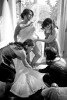 Silvia's brides maids help her put on her wedding dress at her home in Bothell, WA. (Photo by Scott Eklund/Red Box Pictures)