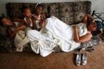 From left, Brittany Powell, 13, Myron Powell, 2,  Deiondrea Powell, 13, and Shawn Powell relaxed in their Houston apartment on a sofa given to them by relatives in January 2006. They were  waiting for FEMA furniture which never arrived.