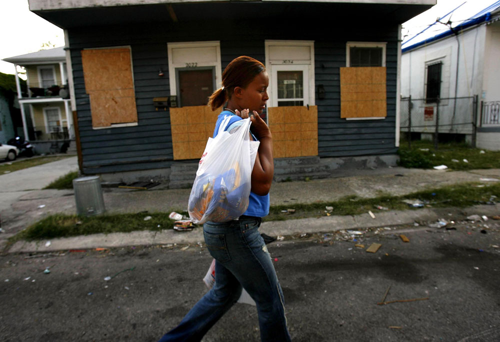 Shawn Powell carries groceries home in late April 2006 in the New Orleans seventh ward neighborhood she lived in for two months with her three daughters, two nieces and young nephew. The family, who was caught in the floodwaters of Hurricane Katrina in their 8th ward neighborhood in August 2005, found that the city was unlivable eight months later. Their duplex, which had been flooded, lacked a gas connection for hot water and debris and garbage littered the neighborhood.