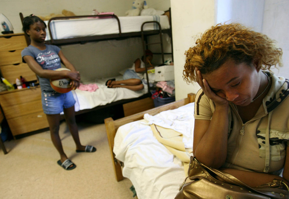 Shawn Powell, right, sits in the room she is sharing with her three daughters, two nieces and young nephew ranging from 2-years-old to 14 in June 2006 at the Salvation Army homeless shelter in Austin where she had been living for several weeks since finding herself homeless after a failed attempt to return to New Orleans.