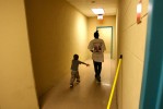 Myron Powell, 2, and his cousin Deiondrea, 13, walk in the corridor of the family dorm in June 2006 at the Salvation Army homeless shelter in Austin where they lived for several weeks after becoming homeless with their aunt Shawn Powell after a failed attempt to return to New Orleans. 