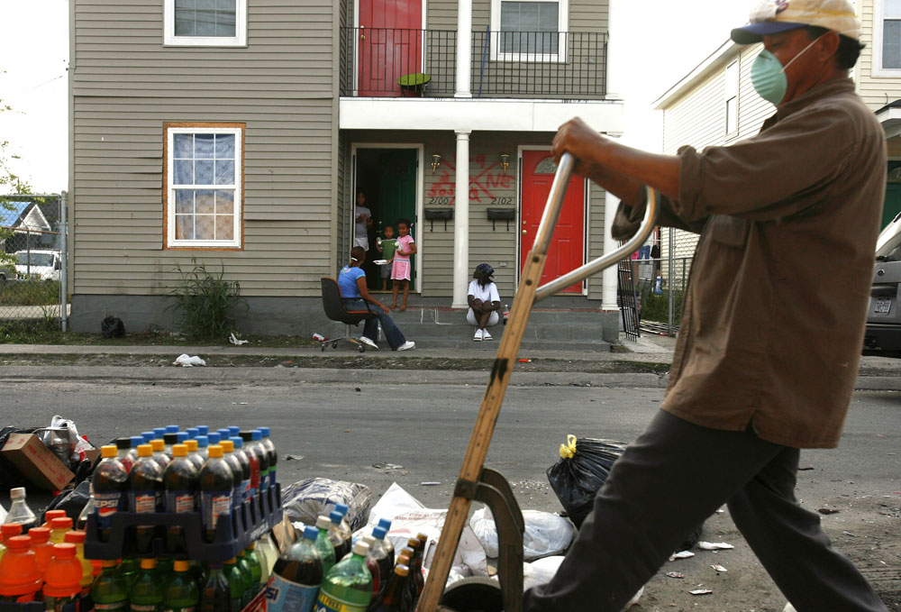 A worker deposits spoiled food and drinks on the street where Shawn Powell and her family were living for two months in the seventh ward neighborhood of New Orleans. The food had been rotting for seven months in the liquor store across the street.