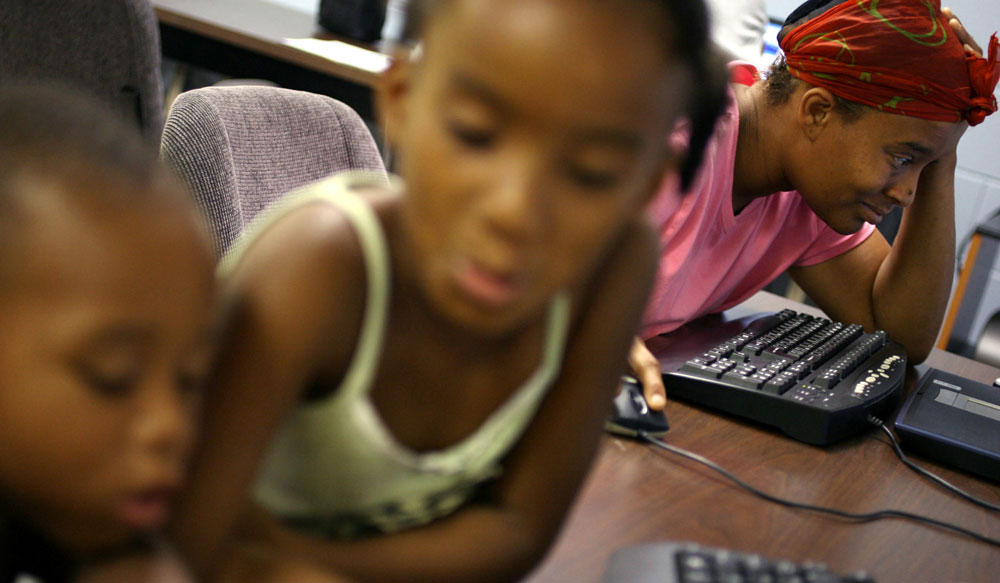 Shawn Powell passes the time in June 2006 checking her e-mail and looking for employment in the computer lab of the Salvation Army in Austin while her daughter Brishawn Powell, 8, and nephew Myron Powell, 2, play next to her. Shawn had grown increasingly frustrated and depressed as she reached the two month mark in the shelter with her three children and three nieces and nephews.