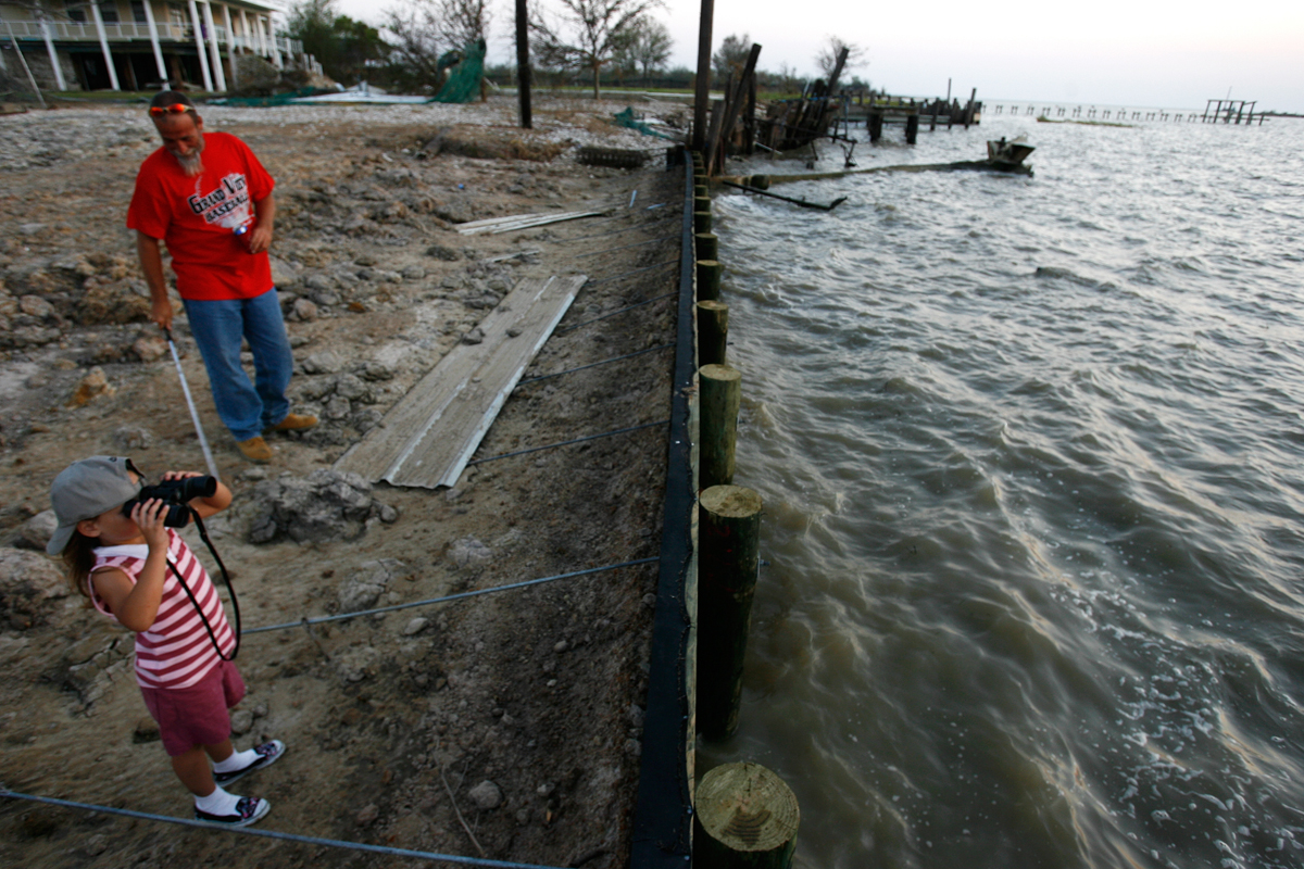 Michael Casonover and his girlfriend's daughter Zoe Key, 6, look out over the bay near the site where they lost their home during Hurricane Ike.