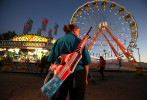 A game attendant displays one of her prizes as she waits for the next player at the Greater Gulf State Fair in Mobile, AL on Oct. 25, 2013. 