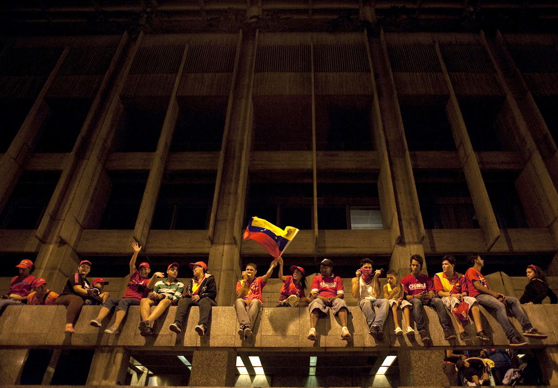 Chavez supporters cheer from a building as thousands took to the streets in downtown Caracas to celebrate his re-election.