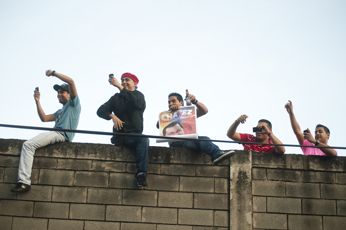 Supporters of President Hugo Chavez cheer as they see him arriving in the Petare neighborhood of Caracas, Venezuela as he continues his re-election campaign on his 58th birthday on Saturday, July 28, 2012.