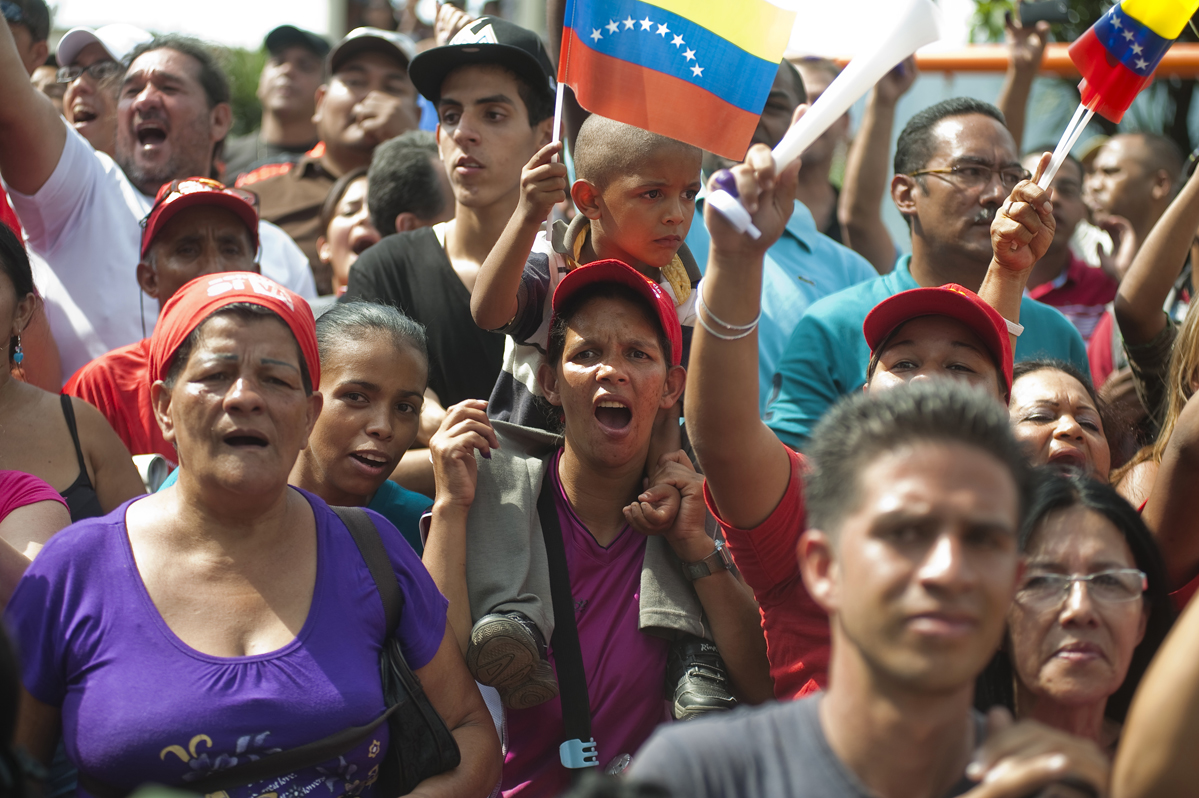 Chavez supporters wave as Hugo Chavez leaves a voting center in Caracas after casting his vote.