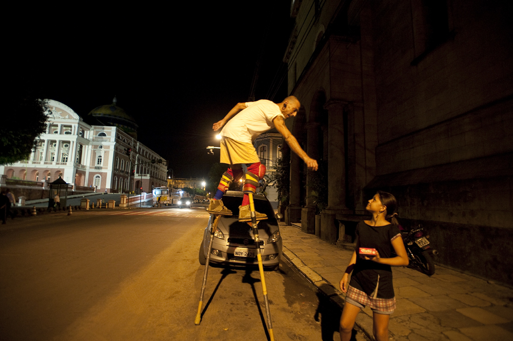 Sergio Bicudo of Manaus greets a passerby as he walks on stilts through St. Sebastian Square in Manaus, Brazil on Wednesday, March 14, 2012. 