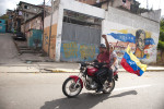 A man and woman ride their motorcycle in Caracas, Venezuela as voting was underway for the country's president on election day October 7, 2012.