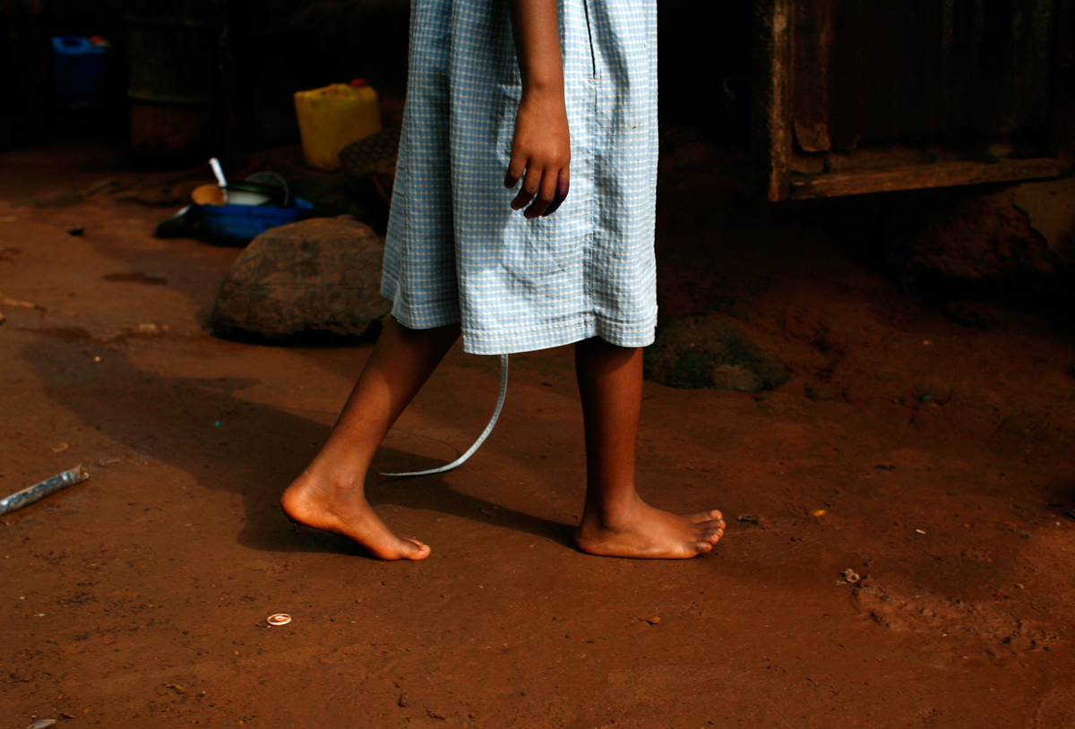 A young neighbor girl walks in the courtyard of Celestina's family home in Urukpaleke in 2008. This is where she paced many years ago the day she left her family. 