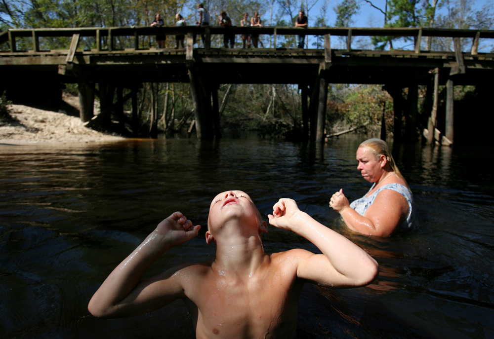 Charlie Simmons, 8, and his mother Frances Simmons, 36, cool off in PWA Creek Thursday in Newton, Texas. She has been taking her four children to the creek almost everyday to cool off and bathe since Hurricane Rita swept through East Texas and knocked out power. 