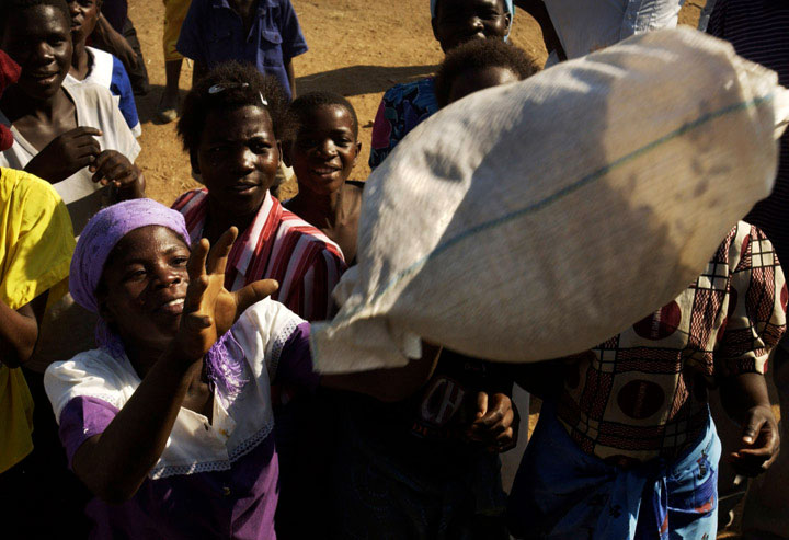 A bag of millet is distributed to a waiting Malawian at a World Food Program distribution site.