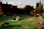 Despite their home being burned out, a Kosovar family still gathers for an afternoon meal on the grounds.