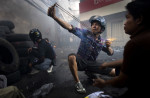 A protester launches a firework in the direction of a military checkpoint.