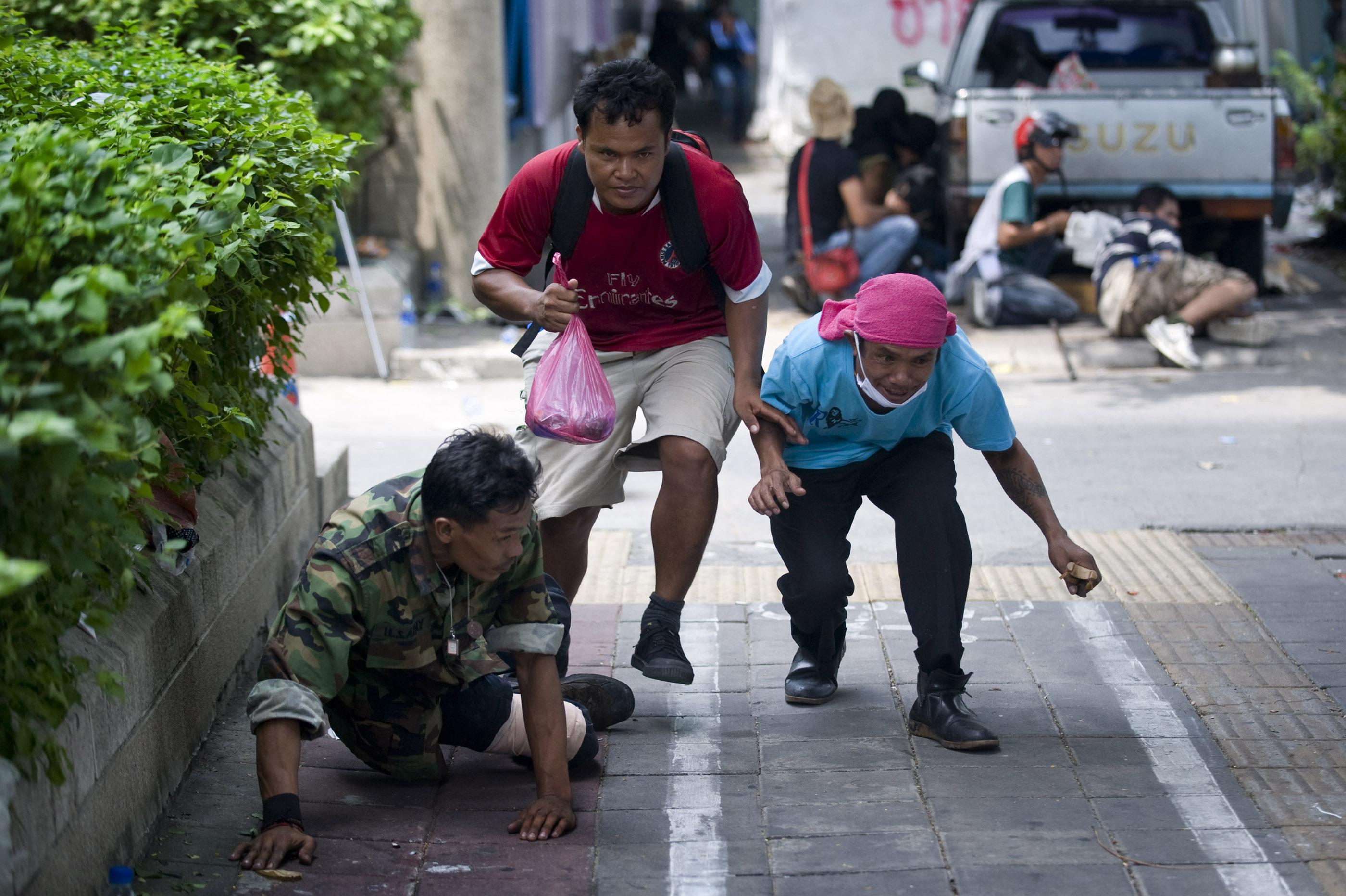 Men run for cover on May 19 as the military begins their crackdown to break up the protests. 