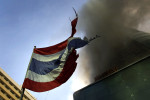 A tattered Thai flag blows as CentralWorld begins to burn. What started as a small fire later engulfed the building.
