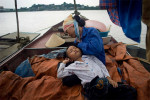 ao Van Bien is held by his mother, Dao Thia Hai, after they greeted each other on the family's boat on the Thai Binh River near Hanoi, Vietnam. Bien's parents work on the river fishing and the kids are unable to see them for long periods of time.