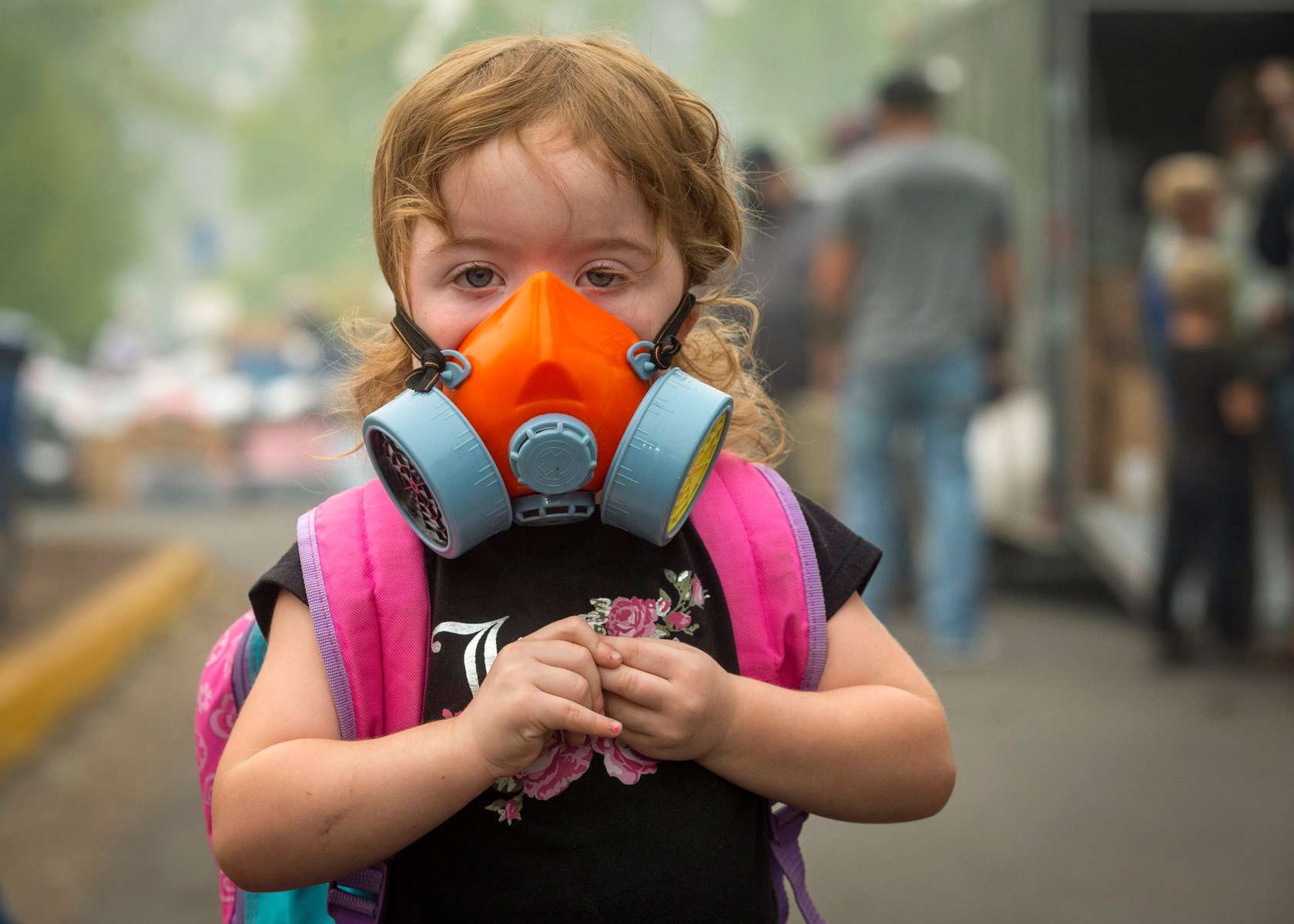 Kailiana Kroeker wears a respirator to protect against hazardous air generated by smoke from the Holiday Fire Farm in Springfield, Oregon. 