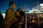 Buddhist monks pray near a barricade erected by anti-government protesters across from Silom Road in Bangkok, Thailand's central business district.