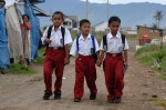 Feri, center, walks to school with friends Muhammad Ikbal, left, and Muksiluddin along their street in the Lampulo neighborhood of Banda Aceh, Indonesia.