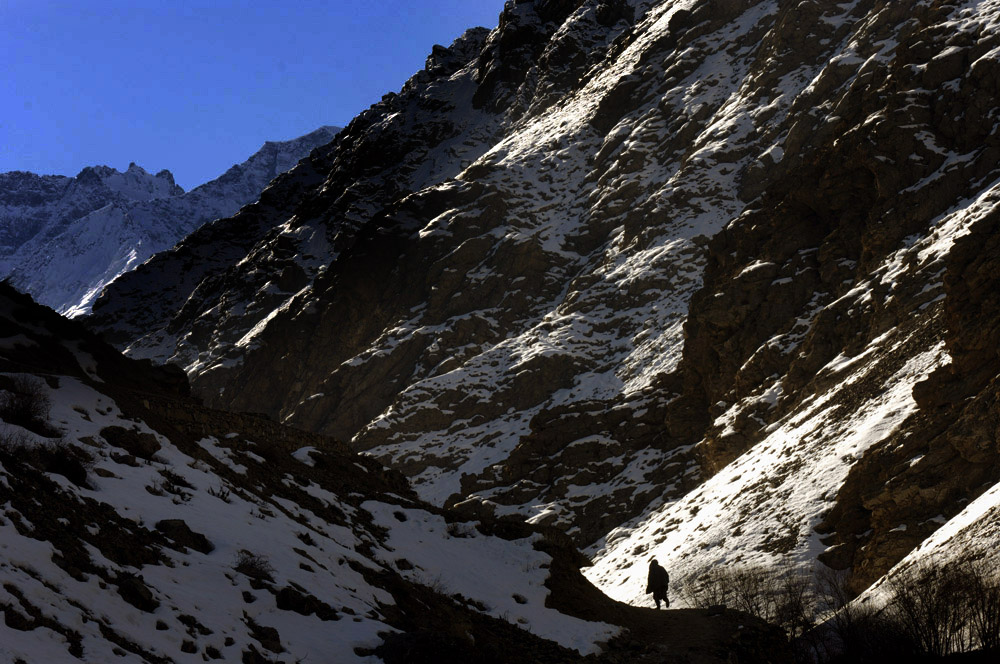 A man walks along the lower section of a path leading from Khenj, Afghanistan to the emerald mines high above the village. The mines are located between 7,000 feet and 14,300 feet above sea level. 