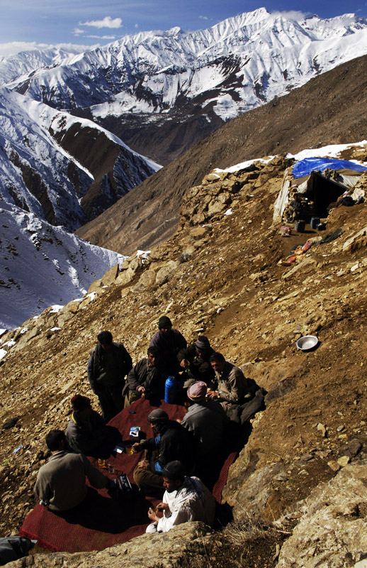 Mohammad Khodir and his friends enjoy tea before lunch at the encampment where he lives with his mining partners high above the village of Khenj, Afghanistan. Other than finding a big emerald, it are times with friends high in the mountains that he enjoys the most about working in the mines. 