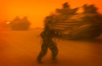A soldier hurries back to his amphibous assault vehicle during a dust storm that paralyzed the U.S. military's surge north.
