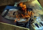 A painting of Saddam Hussein is set alight after being pulled from a military post on the outskirts of Baghdad.