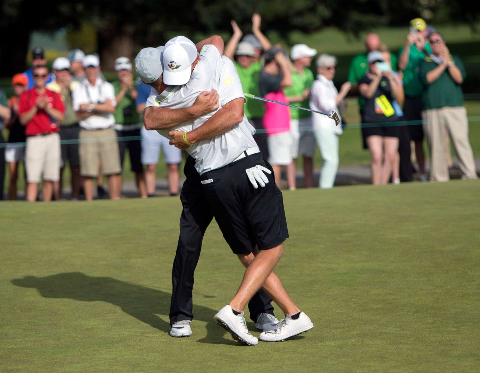 Oregon head coach Casey Martin celebrates with golfer  Sulman Raza after Raza made the match winning putt in his semifinal match against Illinois' Charlie Danielson to send the Ducks into the finals of the NCAA men's golf championship at Eugene Country Club in Eugene.