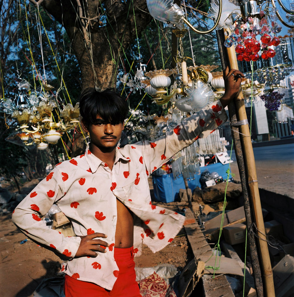 India, Mumbai, February 2008.A young boy standing on the side of the high-way in Mumbai, selling crystal chandeliers.