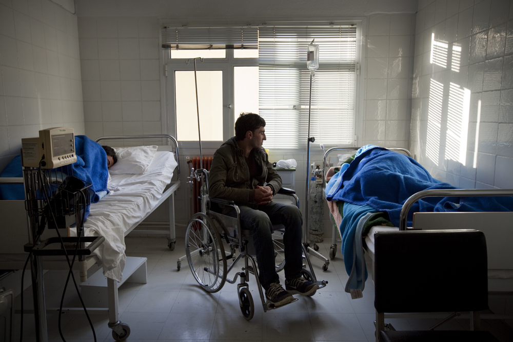 Greece, Polikastro 2015Abed Alrahman 25, waiting in the hospital room after an attack from the mafia inside Macedonia. He has been injured in the war in Syria  having full paralysis in both of his legs. His friends were carrying him throughout the hole journey in their arms and the ones who tried to protect him were severely injured.