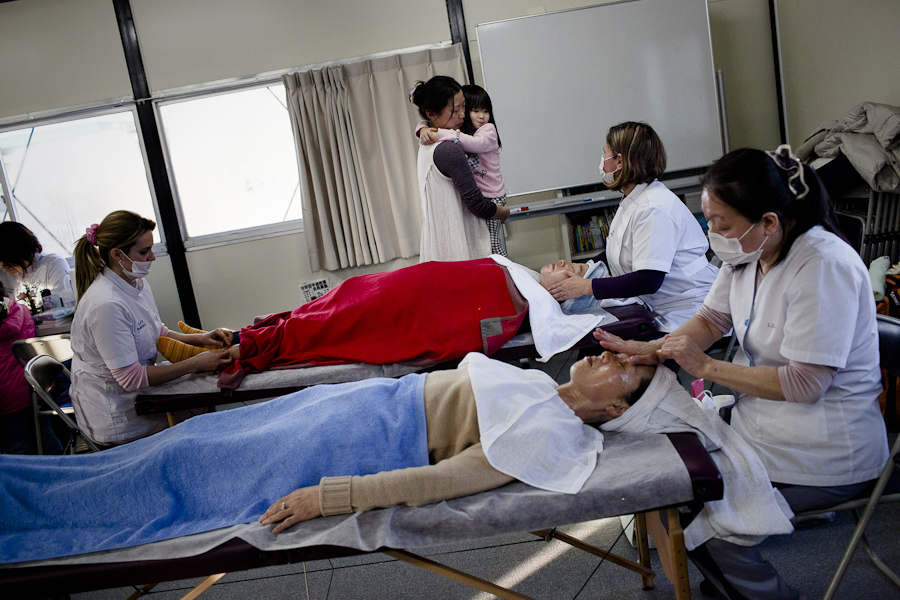 Brazilian massage school students give free treatments to residents of a temporary housing shelter in Ishinomaki, Japan.