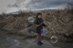 Eight year old Hikari Oyama blows bubbles with her Grandmother after visiting a memorial at Okawa Elementary School. Seventy seven children were killed when a tsunami struck the school on March 11, 2011 near Ishinomaki, Japan. {quote}I thought bubble suits better for children rather than incense sticks [for a memorial]...and it always makes people laugh and relax,{quote} Oyama's grandmother said. 