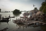 A flood victim stands with his belongings, waiting to be evacuated from his flood destroyed village on September 11, 2010 near the village of Kalimuri, in Sindh province, Pakistan. 