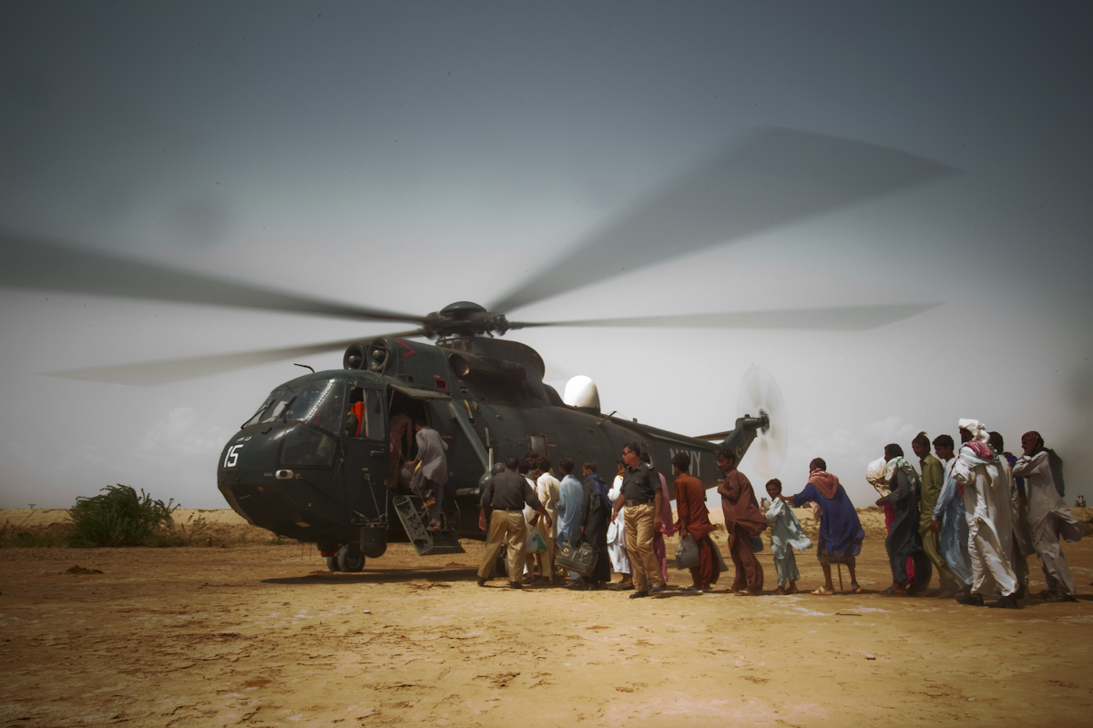Flood victims line up to be evacuated by a Pakistani Navy helicopter in Faridabad, Sindh province on September 13, 2010.
