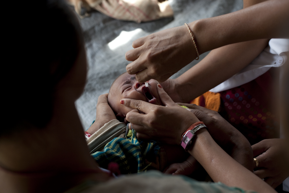 A baby receives a polio vaccination in Upper Assam, on an island in the Brahmaputra River from Akha Boat Clinic staff.