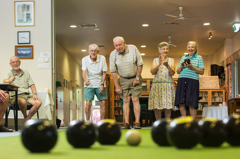 Retirement village residents enjoying a game of indoor lawn bowls 