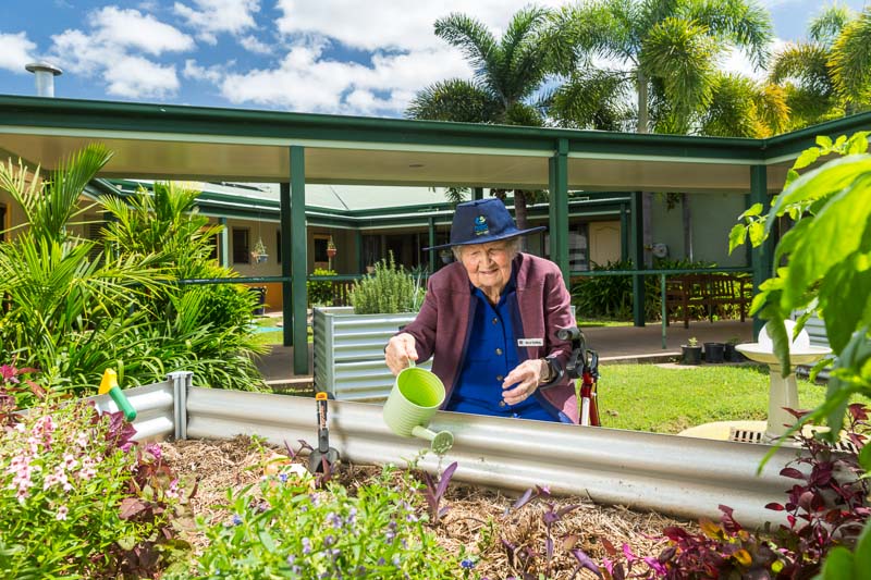 A female aged care resident enjoying some time gardening