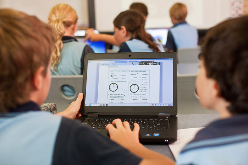 View of students using a laptop for learning in the classroom