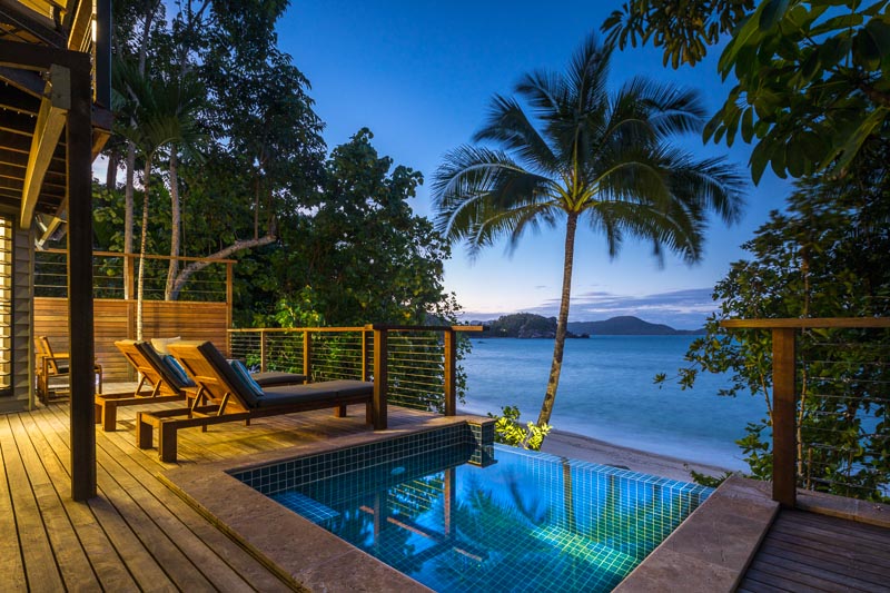 Pool deck of beach villa overlooking the sea at twilight, Bedarra Island Resort