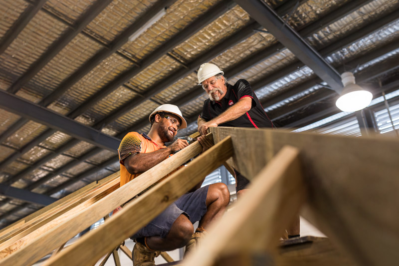 A construction supervisor instructing a student at a building, Cairns