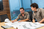 Two fuel service workers checking building plans at an office desk, Cairns